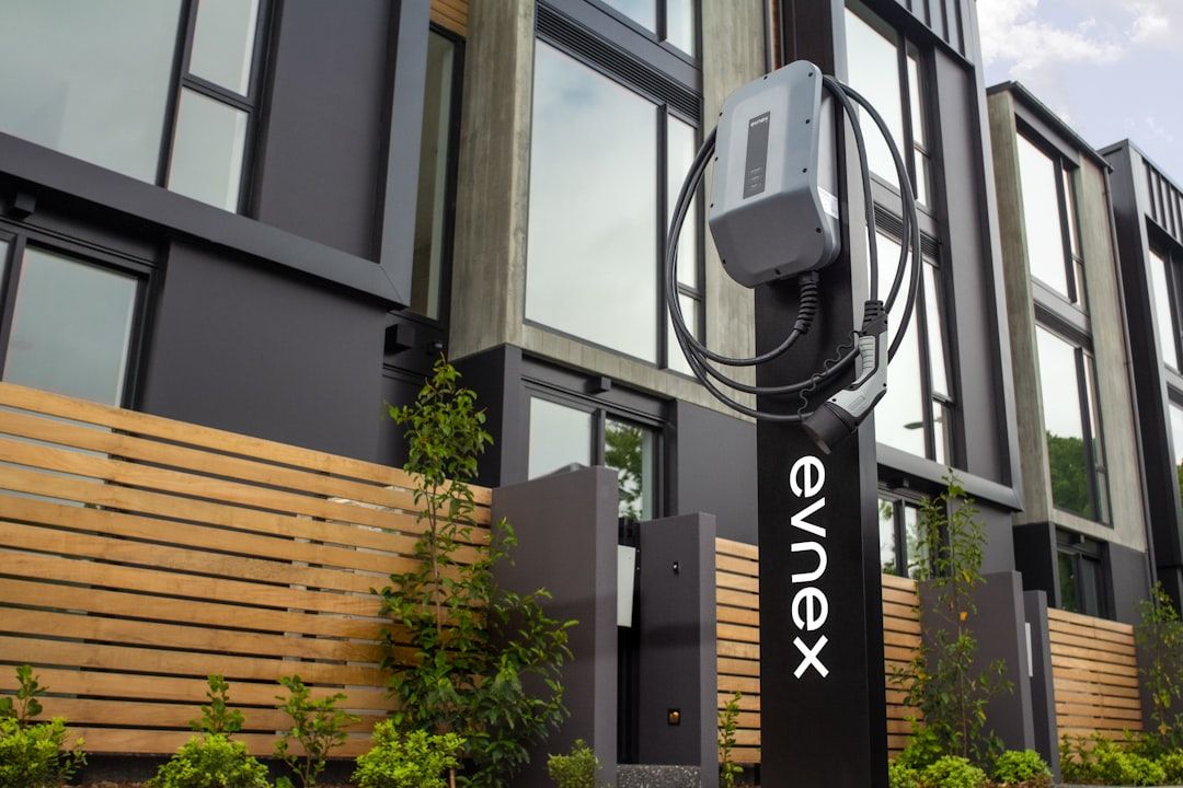 Evnex-sähköauton latausasema modernin asuinrakennuksen edustalla.